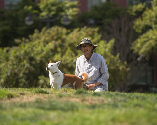 AsianMan_Dog_onGrass_600x400