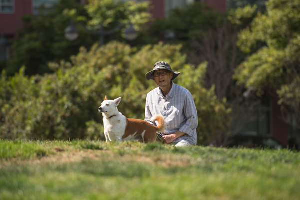 AsianMan_Dog_onGrass_600x400